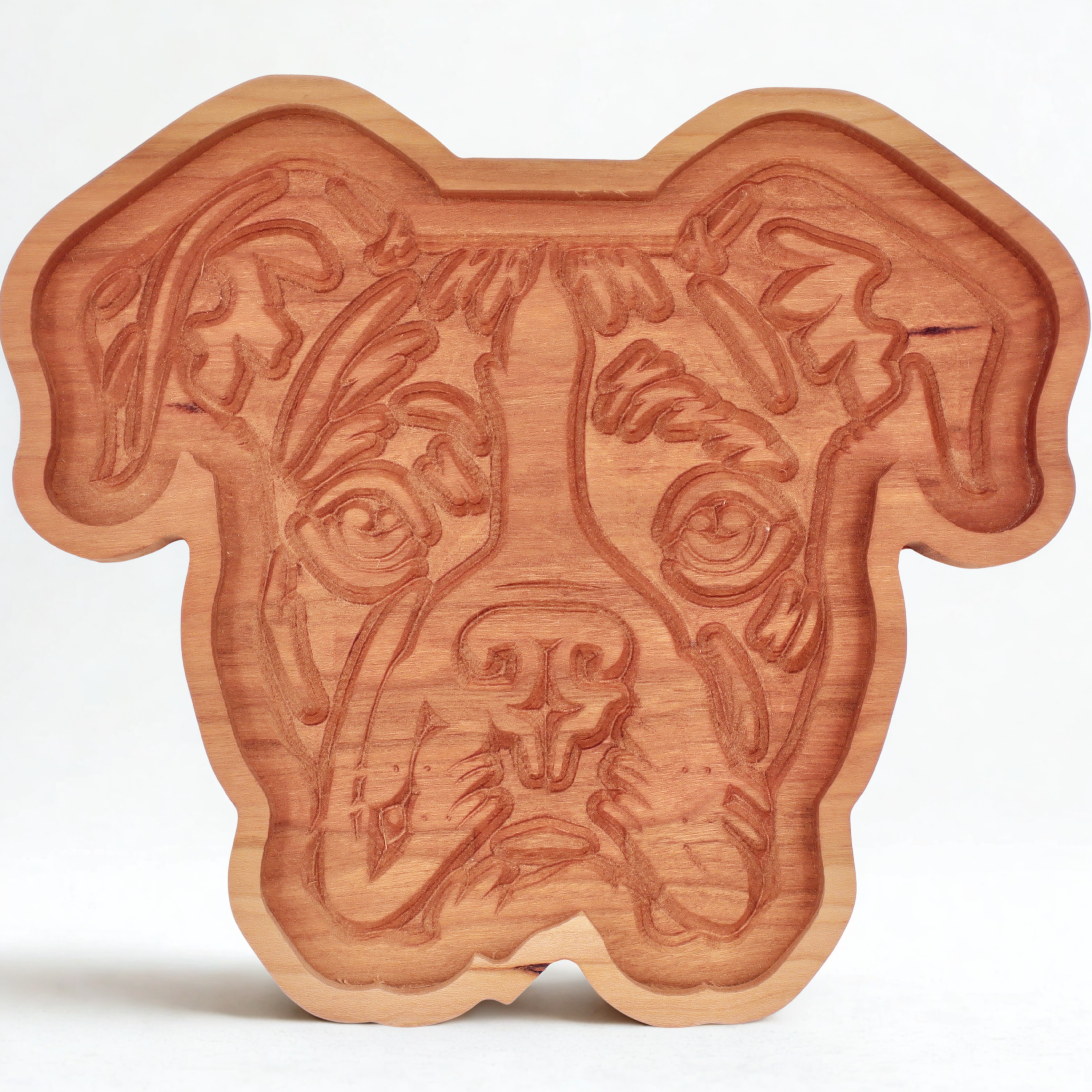 Wooden dog-shaped catch=all tray on a white background