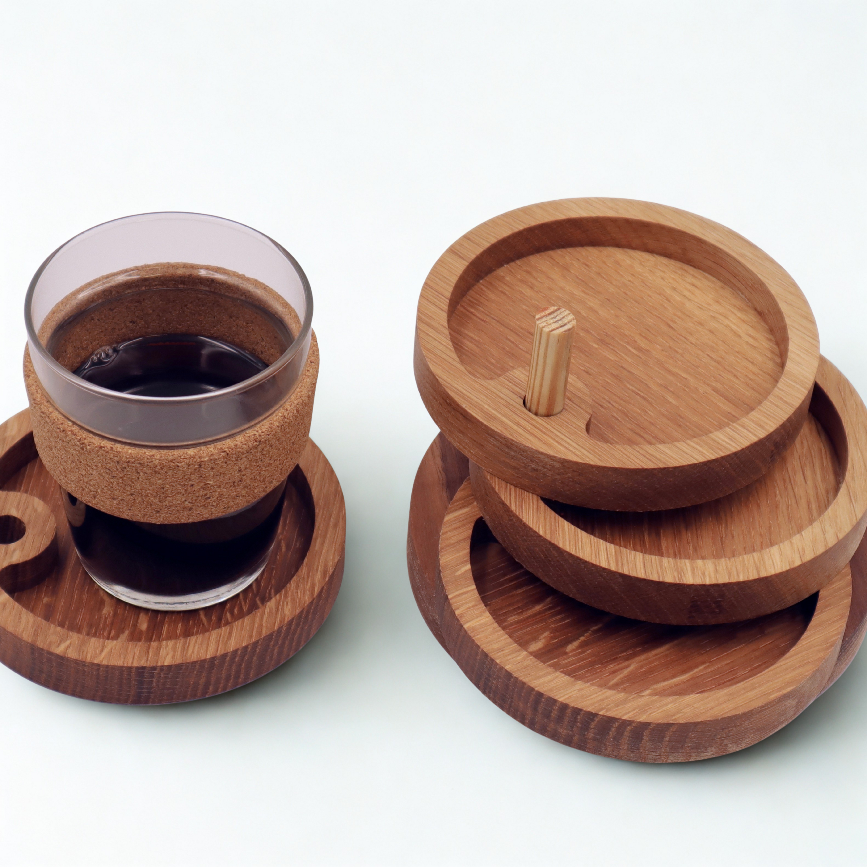 Wooden coasters with a glass of dark liquid on a white background