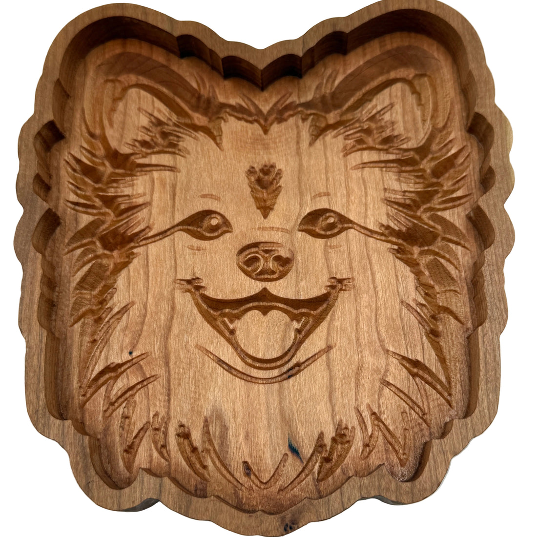 A hand-carved wooden dog face tray with a scalloped edge, shown on a plain white background.