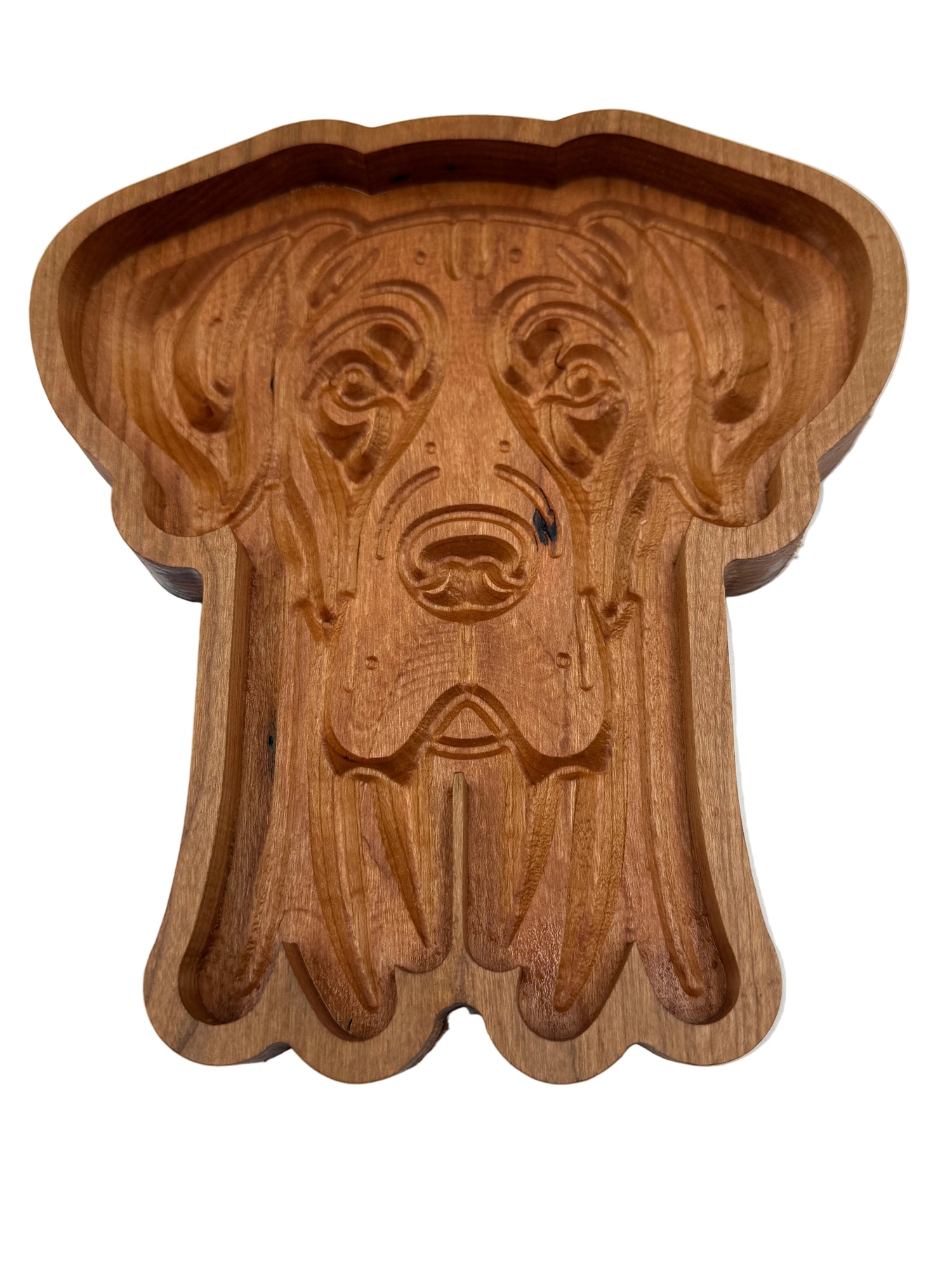 A carved wooden dog-shaped tray or dish with a warm medium-brown wood finish, photographed from above on a plain white background.