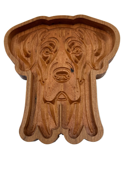 A carved wooden dog-shaped tray or dish with a warm medium-brown wood finish, photographed from above on a plain white background.