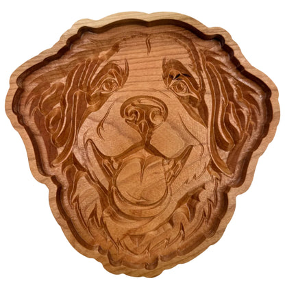 A hand-carved wooden dog head plaque or tray, showcasing detailed wood grain and natural brown tones, set against a plain off-white background.