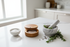Cherry wood salt holder on a marble countertop with rosemary, mortar and pestle and sea salt